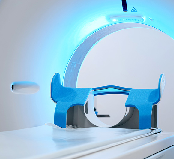 Advanced medical imaging scanner with blue lighting and patient positioning device.