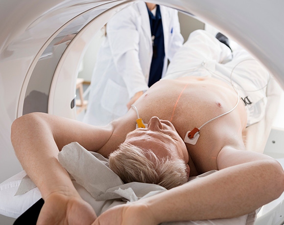 Patient undergoing a cardiac CT scan with medical staff in a hospital setting.