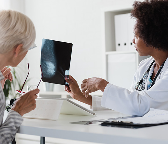Doctor discussing an X-ray image with a patient in a medical office.