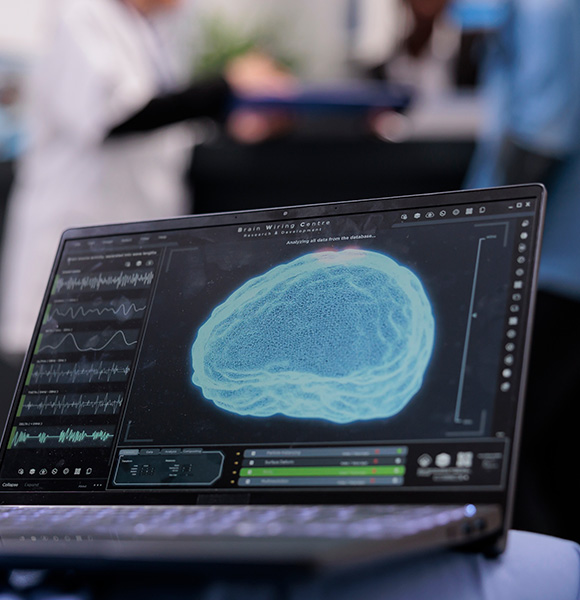 Computer screen displaying brain imaging data with medical professionals in the background.
